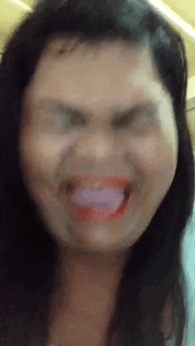 a close up of a woman making a funny face with her tongue sticking out .