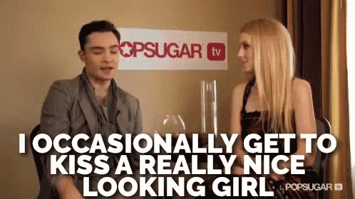 a man and woman are sitting in front of a sign that says popsugar tv .