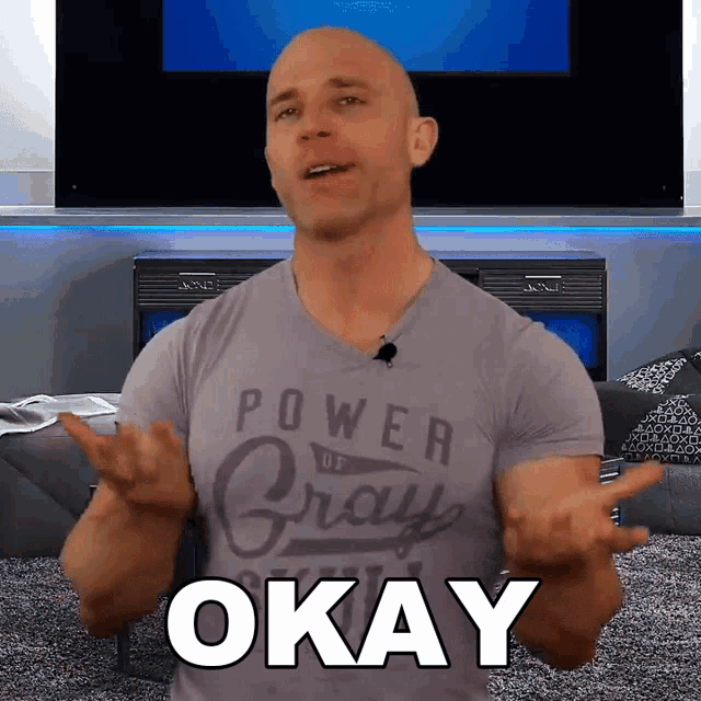 a man wearing a gray shirt that says power to pray okay