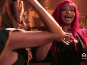 a woman with pink hair is giving a high five to another woman