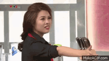 a woman is holding a bunch of knives in her hand and making a funny face