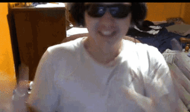 a man wearing sunglasses and headphones is smiling at the camera