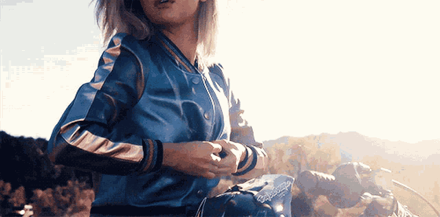 a woman in a blue jacket is sitting on a bike
