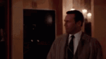 a man in a suit and tie is standing in a room with candles .