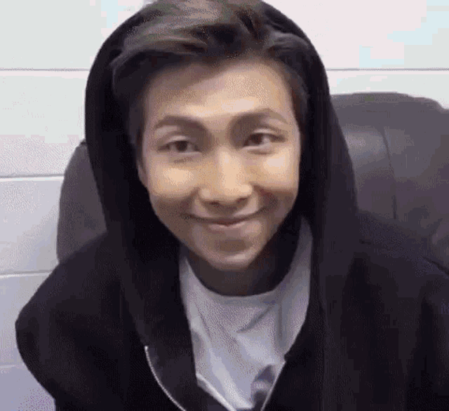 a close up of a person wearing a black hoodie and a white shirt .