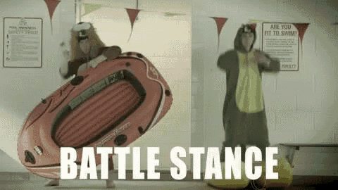 a man in a dinosaur costume is standing next to a man in a raft .