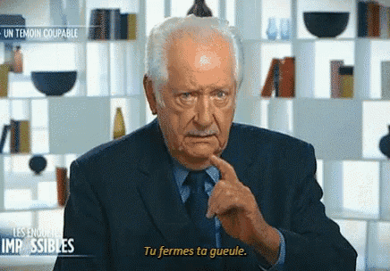 an older man in a suit and tie is talking in french