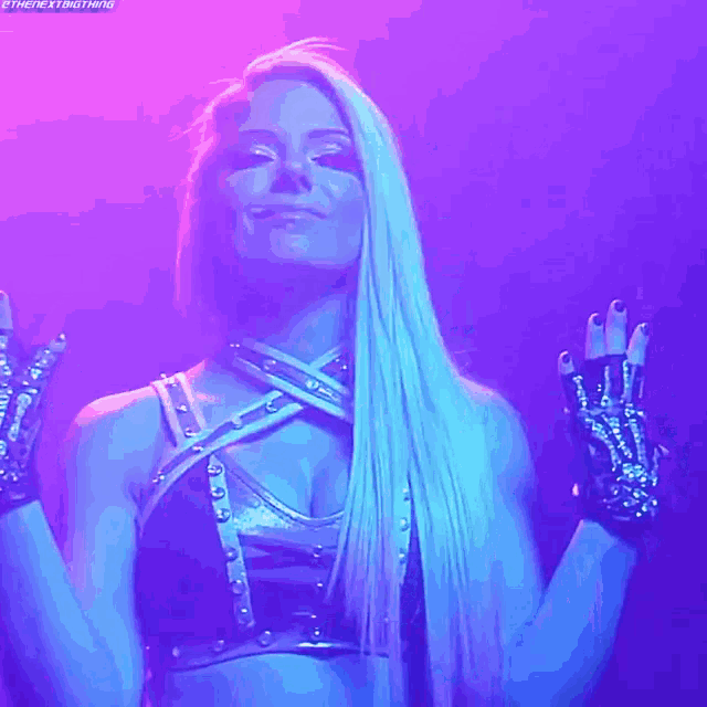 a woman with long blonde hair is wearing a black top and gloves with a purple background
