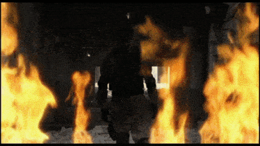 a soldier is standing in front of a large fire