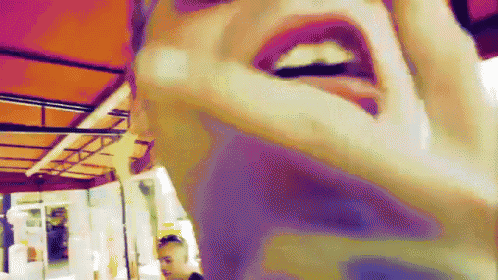 a close up of a woman 's face with her mouth open and her tongue hanging out