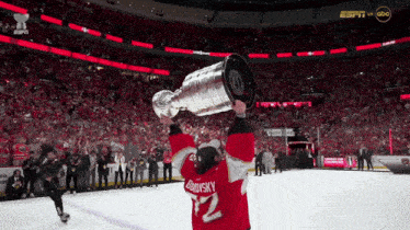 a hockey player holding a trophy with the number 32 on the back