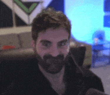 a man with a beard is making a funny face in a room .