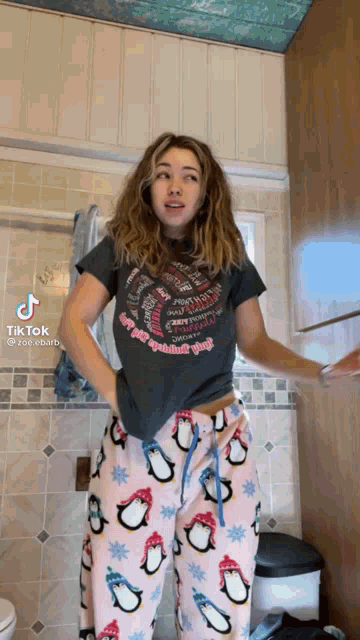 a woman wearing pajamas and a t-shirt that says " happy holidays "