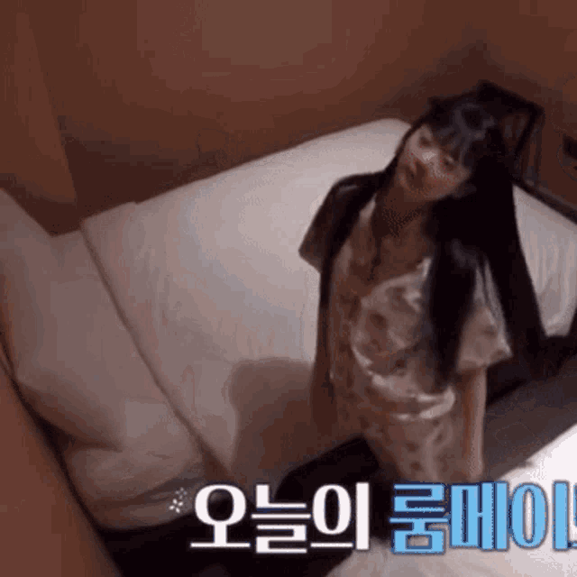 a woman is standing on a bed with korean writing on the bottom