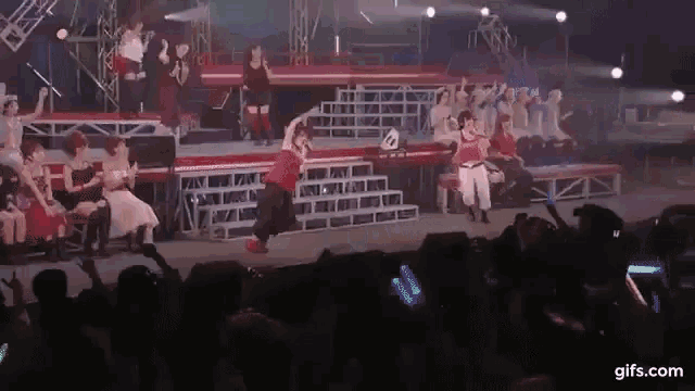 a group of people are performing on a stage in front of a crowd .