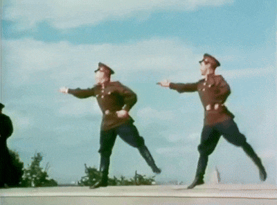 two men in military uniforms are jumping in the air with their arms outstretched