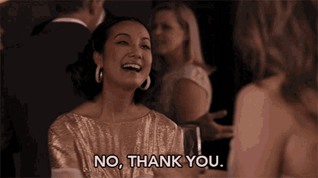 a woman in a gold dress is laughing and saying no thank you