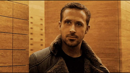 a man wearing a fur coat stands in front of a wall