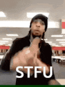 a man is giving the middle finger and the word stfu is on the bottom of the image .