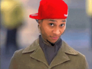 a man wearing a red nike hat and a tan jacket