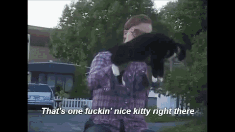 a man is holding a cat in his arms and says `` that 's one fuckin nice kitty right there '' .