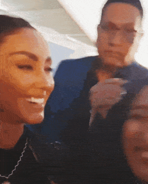 a group of people are standing next to each other and one of them is smiling .