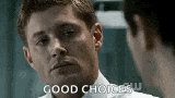 a man in a white shirt is talking to another man in a room .
