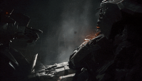 a robotic hand is reaching out towards another robotic hand in the dark