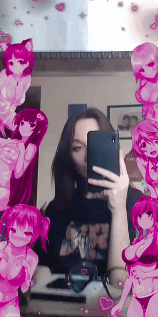 a girl is taking a selfie in front of a mirror with anime girls on the wall .