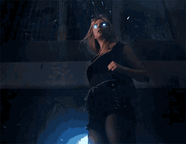 a woman in a black dress has blue eyes