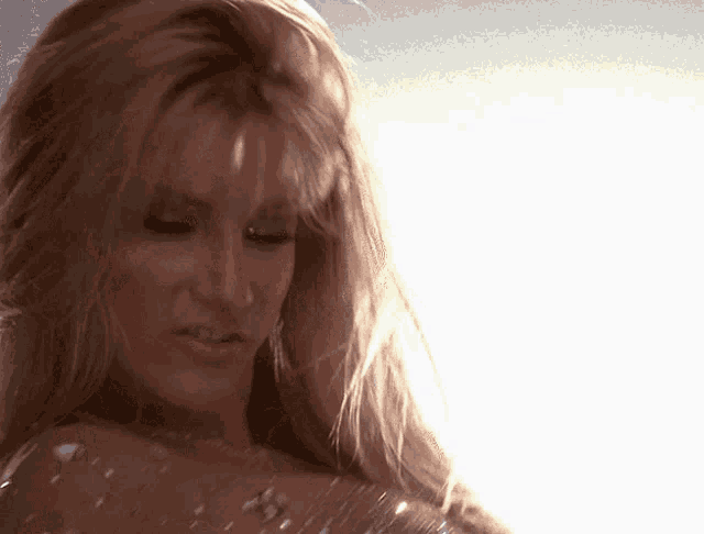 a close up of a woman 's face with the sun shining through her hair
