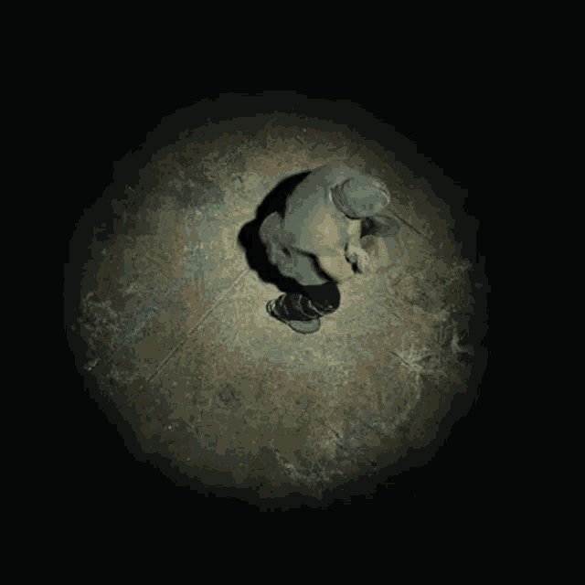 a man is kneeling down in a dark room with a light shining on him