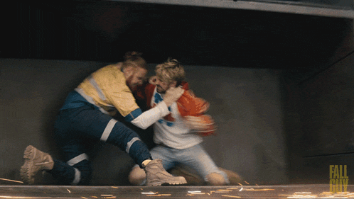 two men are fighting in a dark room with the words fall city on the bottom right