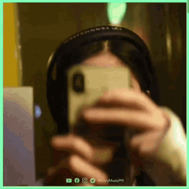 a person wearing headphones takes a picture of themselves