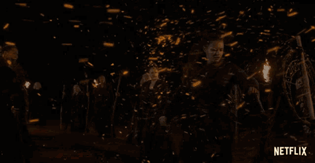 a group of people holding torches with netflix written in the corner
