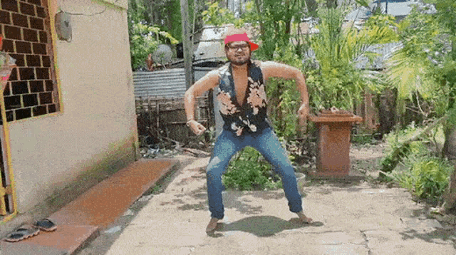 a man in a hawaiian shirt is dancing in a yard