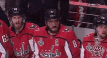 a group of hockey players are standing next to each other in a huddle .
