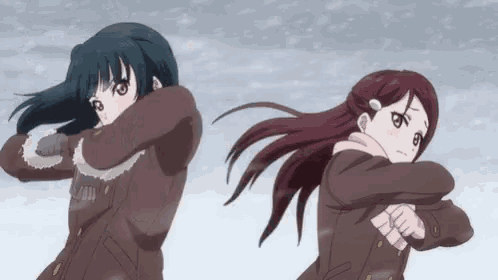 two anime girls are standing in the snow .