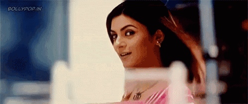 a woman is looking at herself in a mirror while smiling .