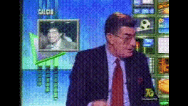 a man in a suit and tie is standing in front of a screen that says " calcio "