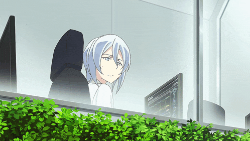 a girl with white hair is sitting in front of a computer screen that says ' a ' on it