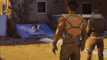 a man in a futuristic outfit stands in front of a house