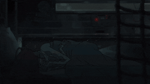 a person is laying on the ground in a dark room with a red light on