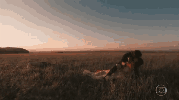 a man and woman are laying in a field with a circle in the middle of the field