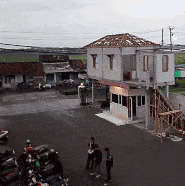 a group of people are standing in front of a building that is being built