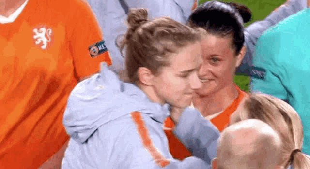 two women are hugging each other on a field .