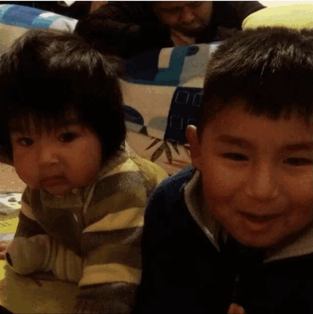 a boy and a baby are sitting next to each other