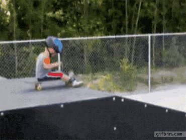 a young boy is riding a scooter on a skate park and the website gifbin.com is at the bottom of the screen