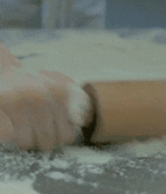a person is rolling a piece of dough with a rolling pin