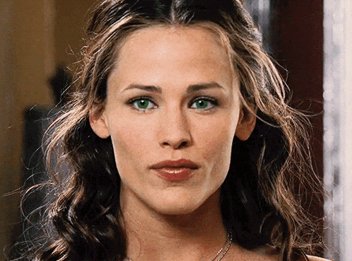 a close up of a woman 's face with green eyes and brown hair